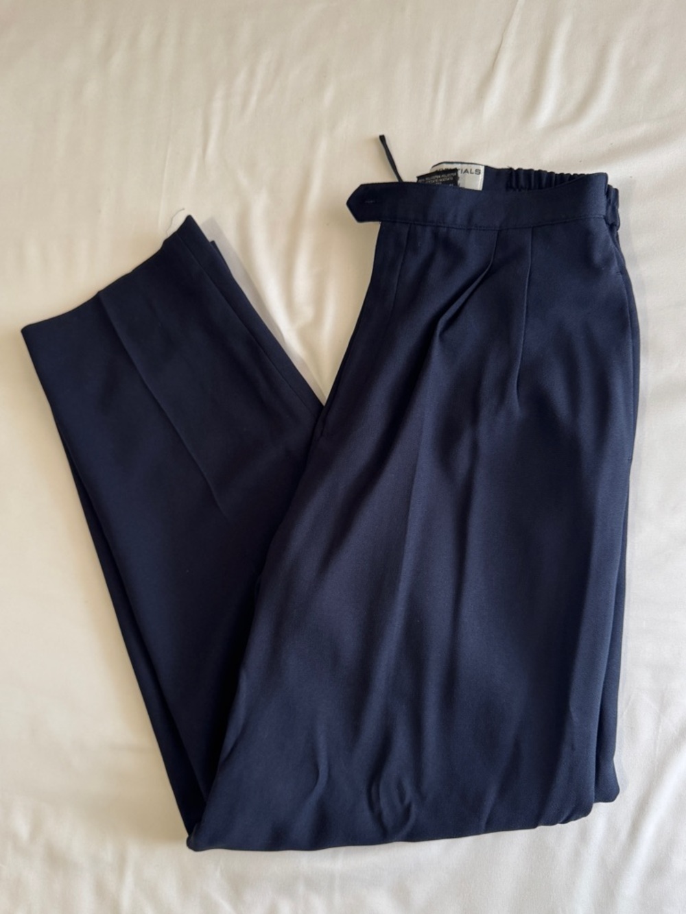 Navy blue high-waisted straight-leg dress pants, with pleats and pockets